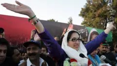 Pakistani former premier Benazir Bhutto waves to her supporters as she arrived for an election campaign rally in Rawalpindi 27 December 2007.