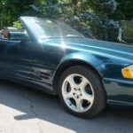 Front view of a 1990s Mercedes-Benz R129 SL-Class SL600 with the top down, showcasing its classic roadster design