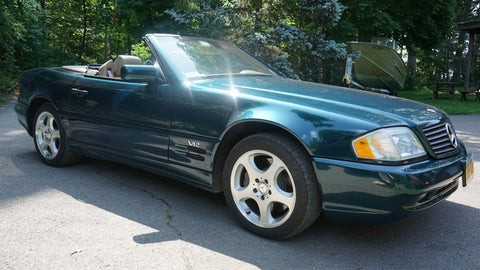 Front view of a 1990s Mercedes-Benz R129 SL-Class SL600 with the top down, showcasing its classic roadster design