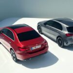 Exterior view of two Mercedes-Benz A-Class hatchbacks in a promotional setting, showcasing their modern and compact design.