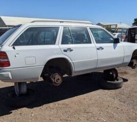 Front view of a clean, silver 1994 Mercedes-Benz E 320 wagon in a junkyard, showcasing its remarkably preserved condition.