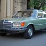 Front three-quarter view of a 1975 Mercedes-Benz 280S in silver, showcasing its classic design and elegant lines.