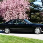 Front profile of a 1990 Mercedes-Benz 560SEC for sale, showcasing its coupe design and body-colored cladding.