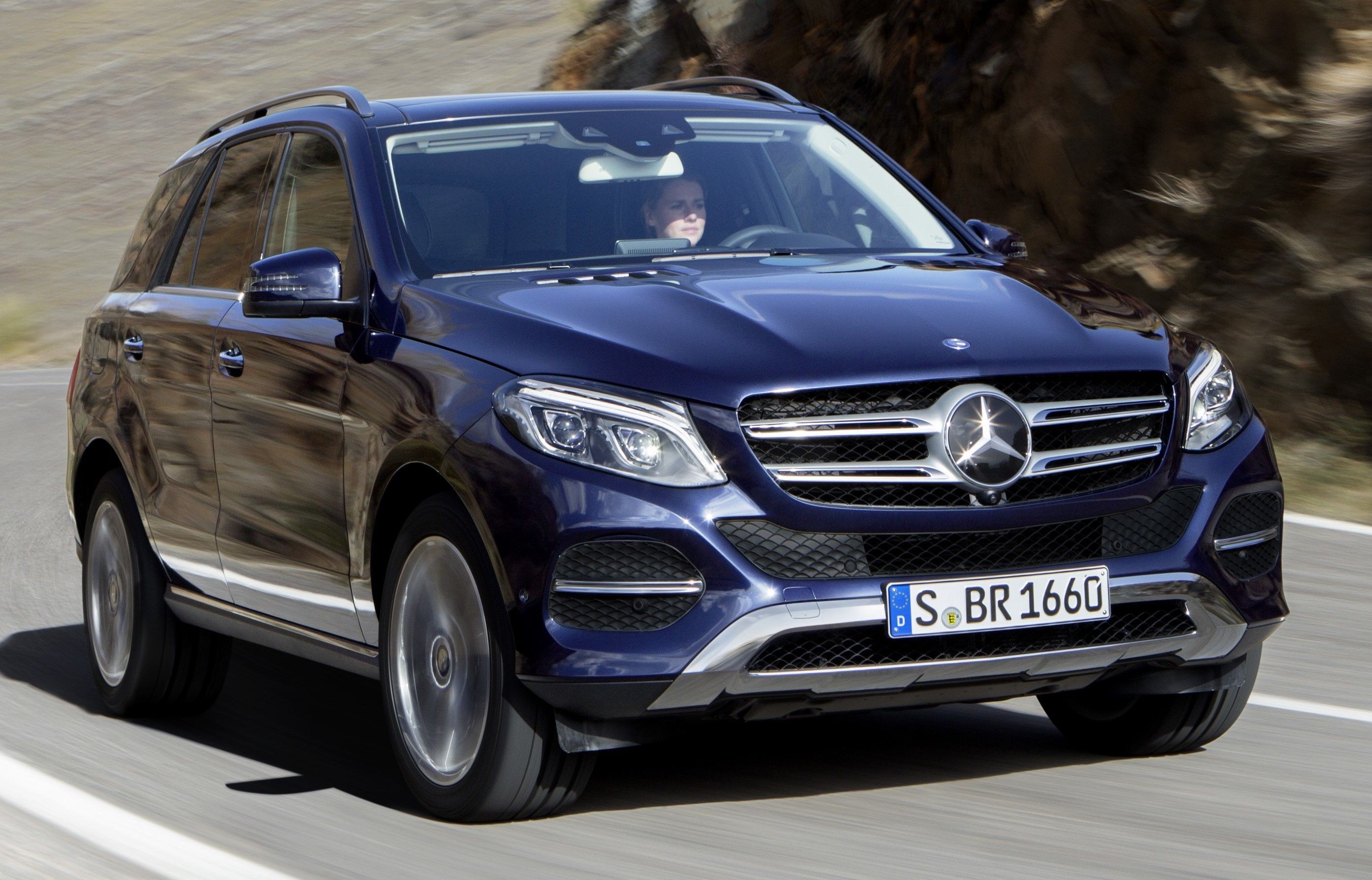 A 2017 Mercedes-Benz GLE-Class driving on a scenic road, emphasizing its luxurious presence and comfortable ride.