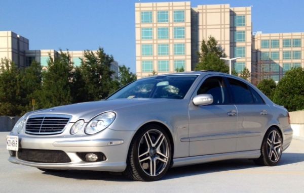 Front view of a silver Mercedes Benz AMG E55 W211, showcasing its powerful stance and headlight design, highlighting its value as a performance sedan.