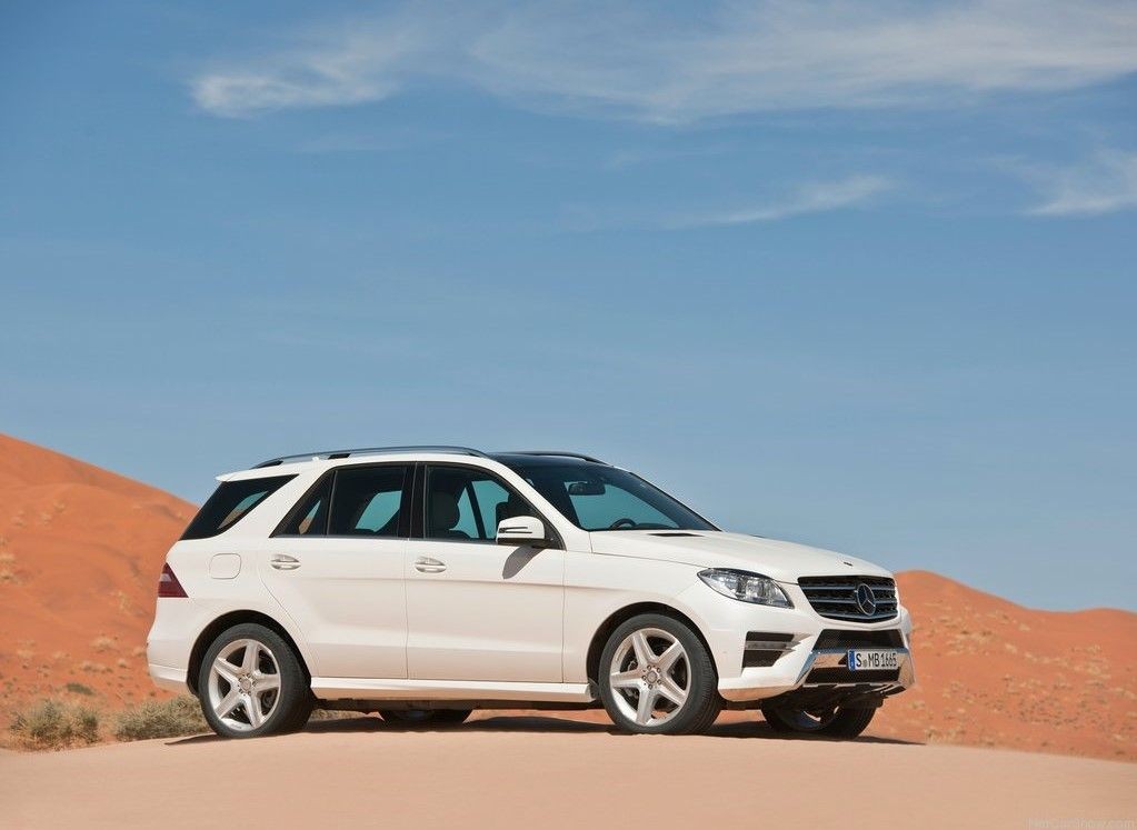 Front three-quarter view of a white 2012 Mercedes-Benz M-Class, emphasizing its robust SUV stance and recognizable Mercedes-Benz grille.