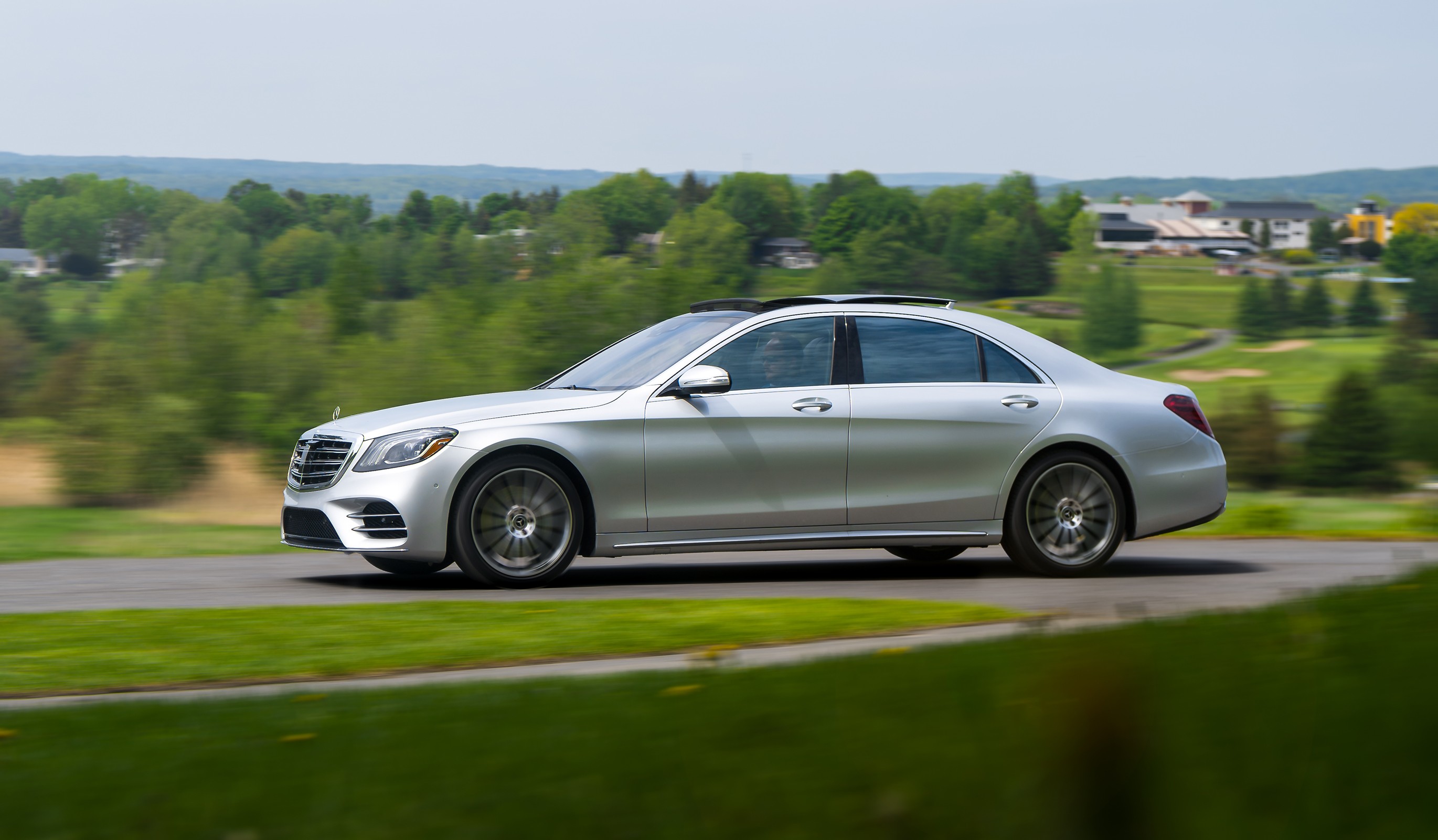 Front exterior view of a silver 2018 Mercedes-Benz S560 luxury sedan parked on a paved area showcasing its elegant design and iconic grille.